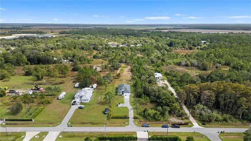 View of property location featuring a forest and a nearby body of water