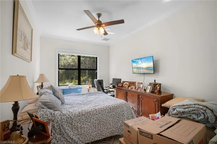 Bedroom featuring crown molding, ceiling fan, and a desk