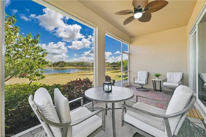View of patio featuring a ceiling fan, a sunroom, and a water view