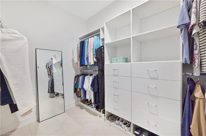 Walk in closet with light tile patterned floors