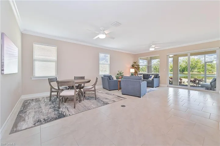 Dining space featuring ceiling fan, ornamental molding, plenty of natural light, and light tile patterned floors