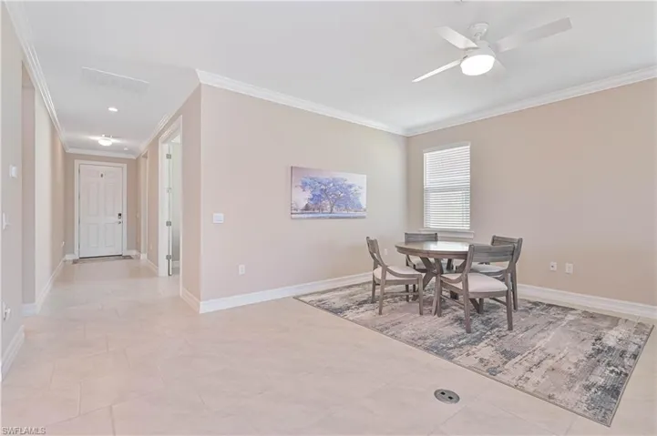 Dining room featuring ornamental molding, ceiling fan, and light tile patterned flooring