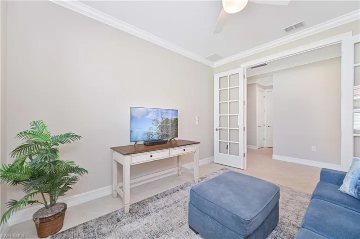 Sitting room with crown molding, a ceiling fan, french doors, and light tile patterned floors