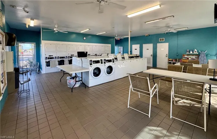 Communal laundry room with separate washer and dryer, a ceiling fan, and electric panel