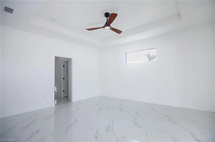 Spare room with a raised ceiling and ceiling fan