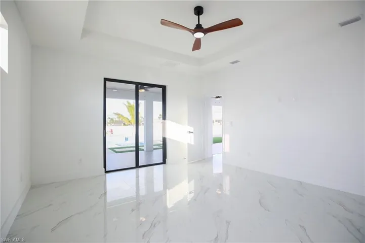 Spare room featuring a tray ceiling and ceiling fan