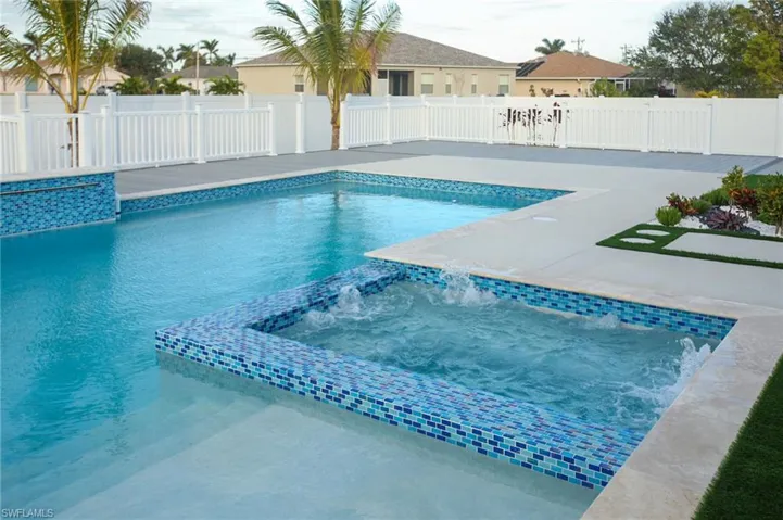 View of swimming pool featuring an in ground hot tub, pool water feature, and a patio