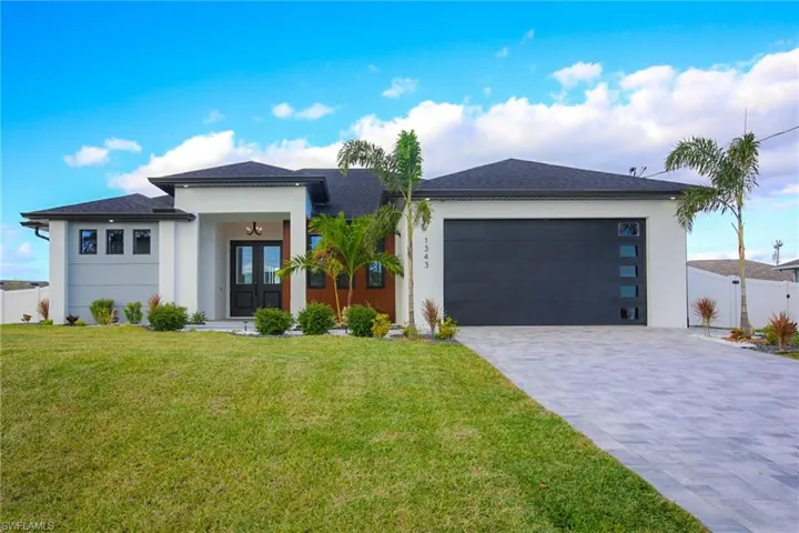 Prairie-style home featuring a front lawn, a garage, and french doors
