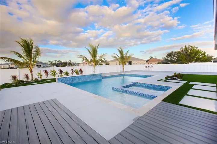 View of pool featuring a lawn, a patio area, and an in ground hot tub