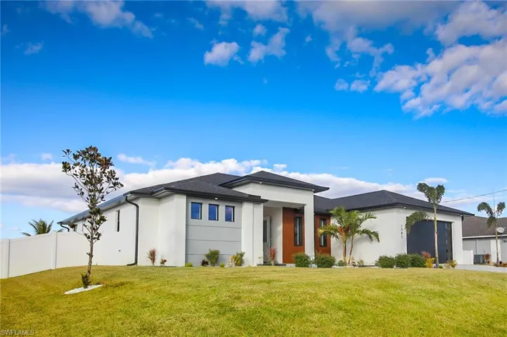 View of front of property with a garage and a front yard
