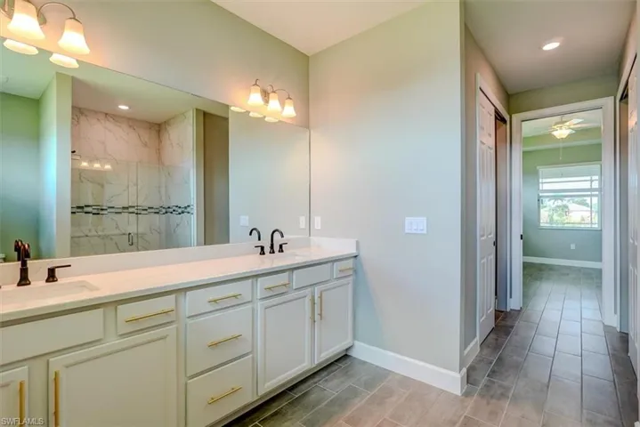 Bathroom featuring a tile shower and vanity