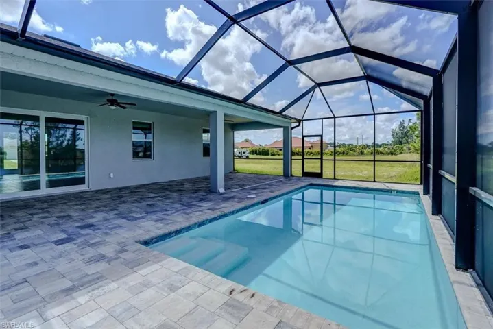 View of swimming pool featuring ceiling fan, a lanai, and a patio area