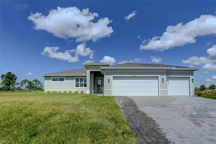 View of front of property with a front yard and a garage