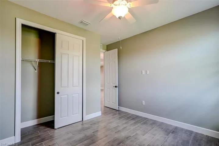 4th bedroom with ceiling fan, hardwood / wood-style flooring, and a closet