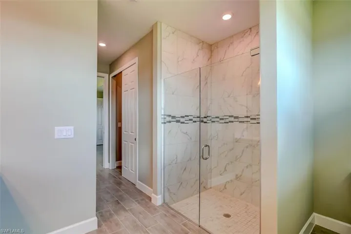 Bathroom featuring wood-type flooring and a shower with door