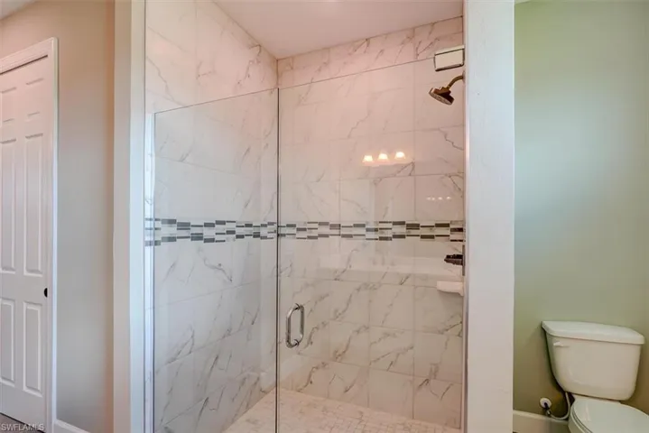 Bathroom with toilet and a shower with shower door