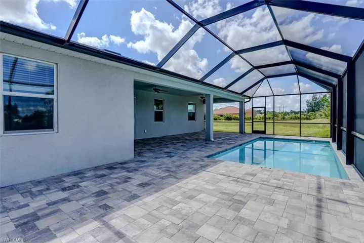 View of pool with a lanai, a patio, and ceiling fan