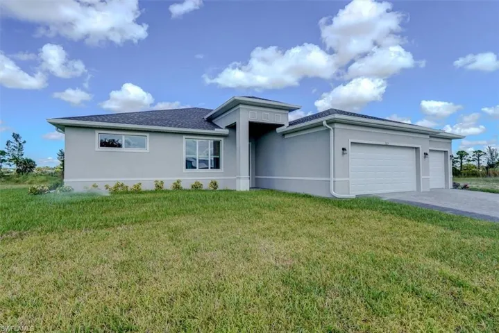 View of front of house featuring a front lawn and a garage