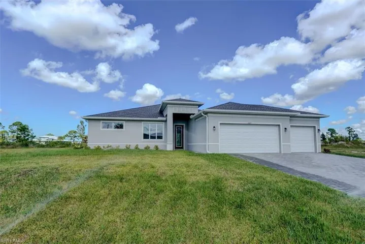 View of front of house with a garage and a front lawn