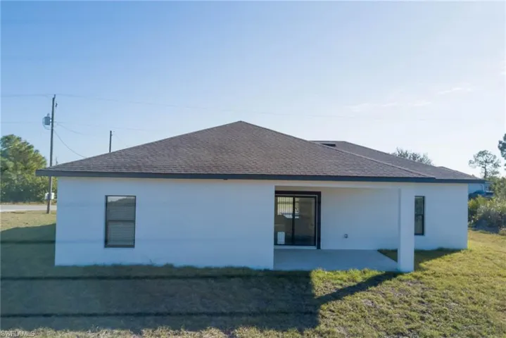 Back of property featuring a yard and a patio