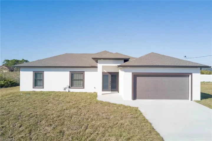 View of front of house with a garage and a front lawn