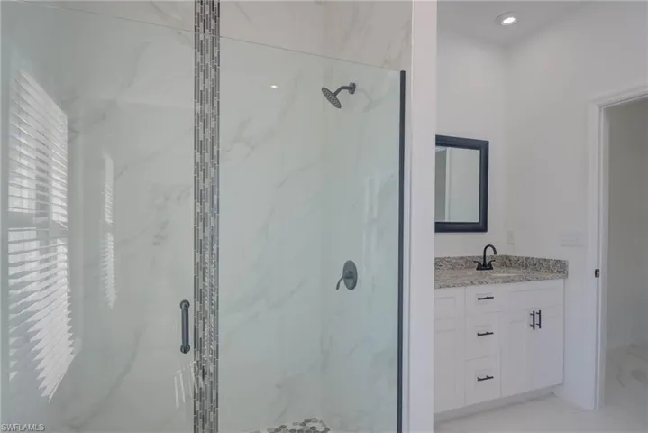 Bathroom featuring vanity and a shower with shower door