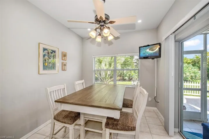 Dining area with ceiling fan, sliders to lanai and light tile floors