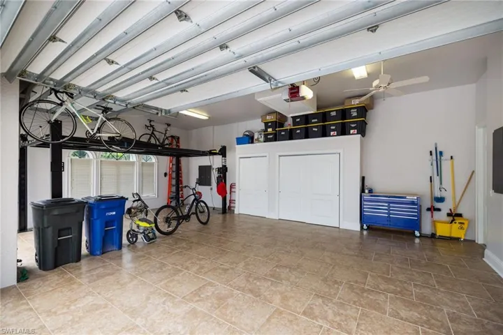 Garage featuring a garage door opener, electric panel, and a ceiling fan