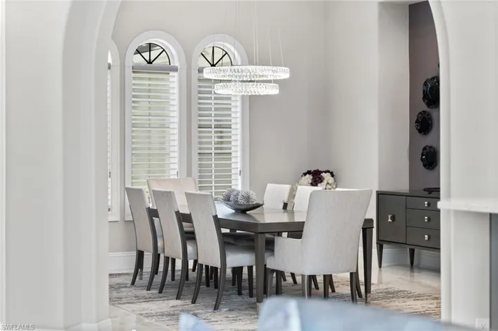 Dining space featuring arched walkways and a chandelier