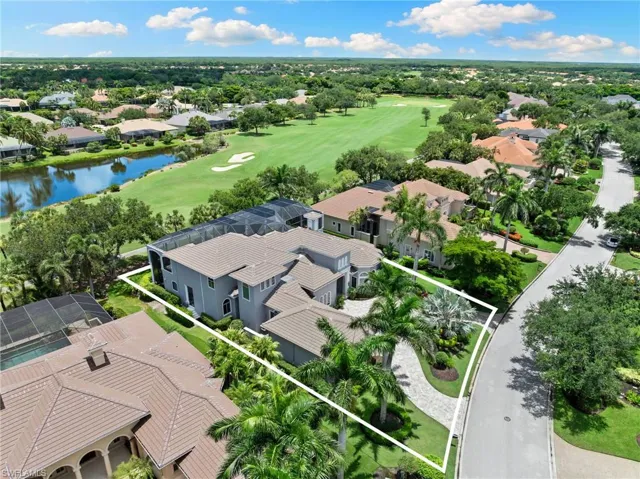 Aerial perspective of suburban area with a golf club, property parcel outlined, and a nearby body of water