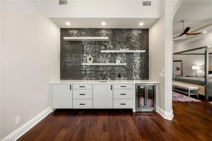 Indoor wet bar featuring white cabinetry, open shelves, ceiling fan, tasteful backsplash, and recessed lighting