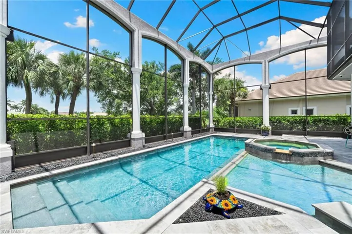 View of pool featuring a lanai and a pool with connected hot tub