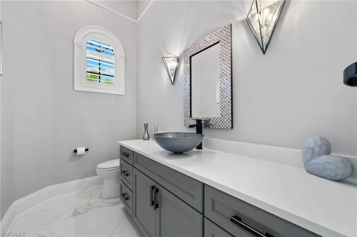 Bathroom with marble look tile flooring and vanity