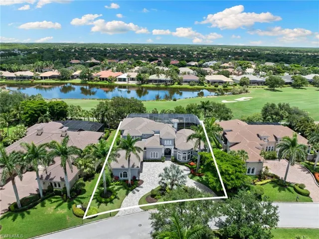 Aerial view of residential area featuring property boundaries highlighted and a nearby body of water