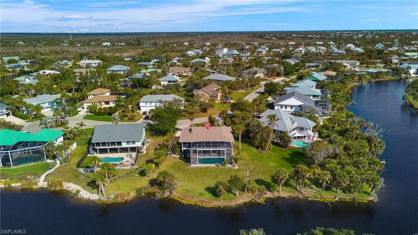 Aerial view of property's location with a nearby body of water and nearby suburban area