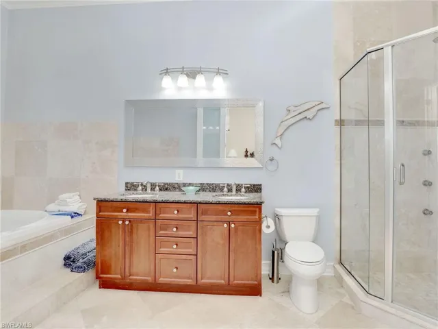 Full bathroom featuring vanity with extensive cabinet space, dual sinks, tile floors, and plus walk in shower