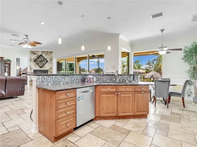 Kitchen featuring hanging light fixtures, ceiling fan, dishwasher, and light tile floors