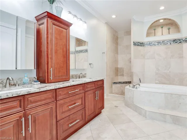Bathroom featuring tile floors, ornamental molding, plus walk in shower, and dual bowl vanity