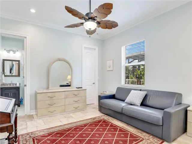 Tiled living room with ceiling fan and crown molding
