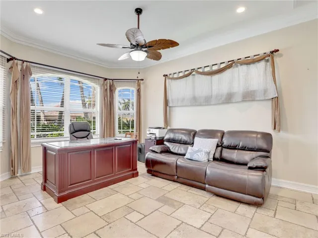 Tiled living room featuring ceiling fan and crown molding