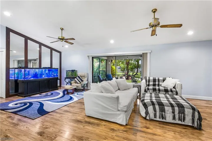Living room with ceiling fan and hardwood / wood-style floors