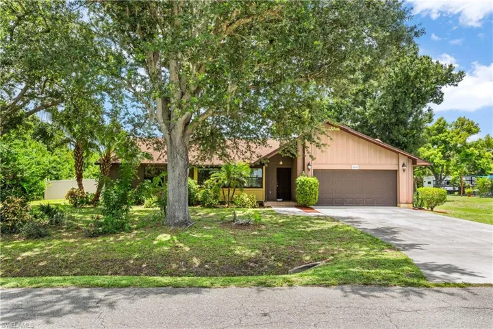 View of front of property featuring a garage and a front yard