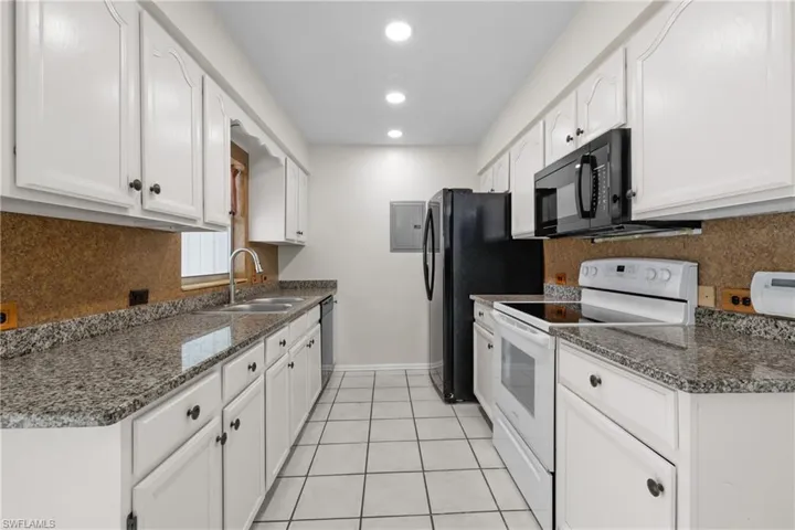 3/3 Side:  Kitchen featuring dishwasher, white cabinetry, a sink, microwave, and electric range