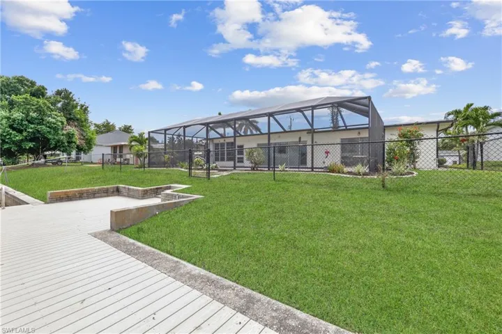 View of yard with glass enclosure and a fenced backyard