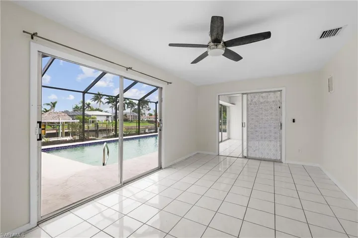 3/3 Side: Bedroom featuring light tile flooring, baseboards, visible vents, and ceiling fan