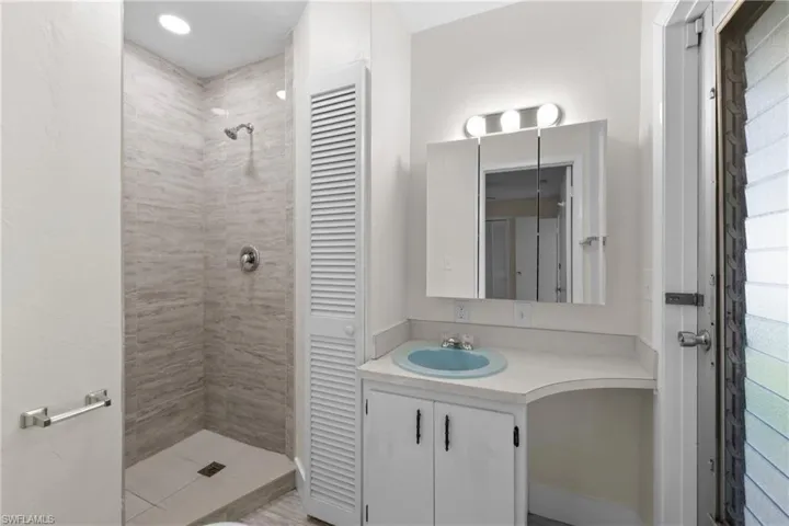 3/3 Side: Bathroom with a tile shower and vanity