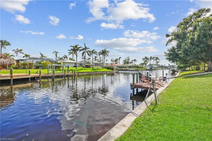 Fenced backyard with canal view and seawall.