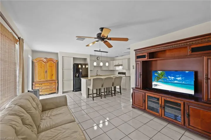 1/1 Side of Duplex. Living area featuring full kitchen, living room and light tile floors