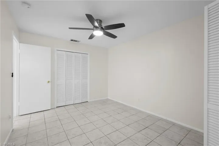 3/3 Side: Bedroom featuring baseboards, visible vents, a closet, and ceiling fan