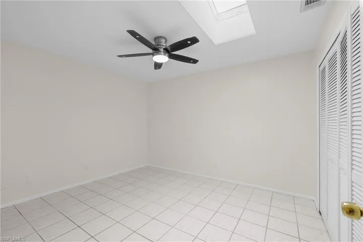 3/3 Side: Bedroom with a ceiling fan, a skylight, and baseboards
